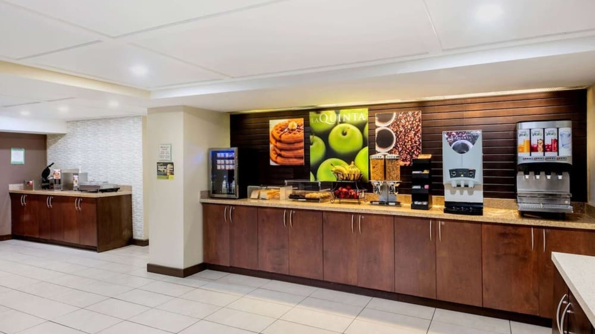 Breakfast area with self-serve coffee, juice, and buffet stations at La Quinta Inn & Suites By Wyndham Oshawa.