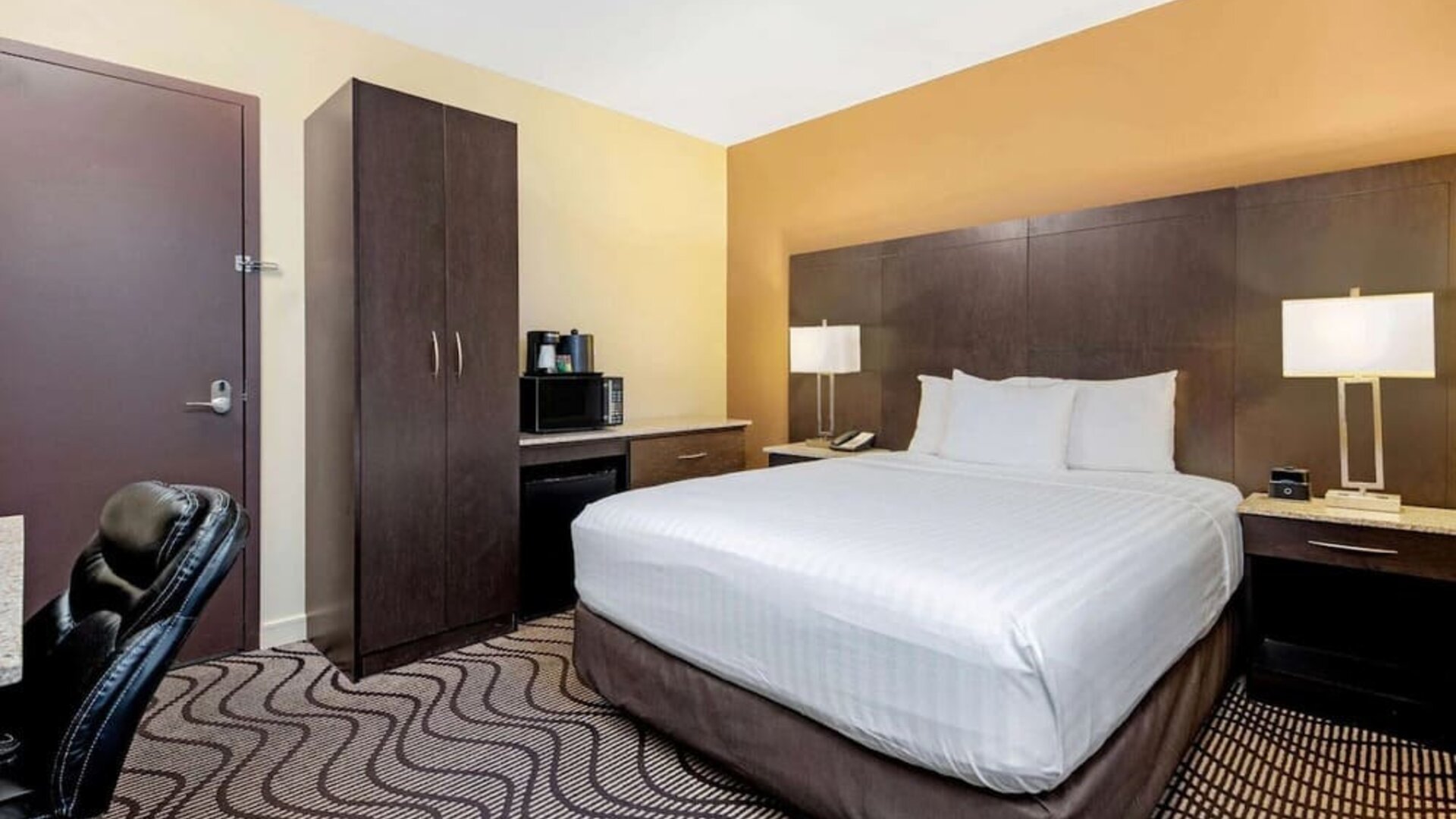 Guest room with a king bed, microwave, and mini fridge at La Quinta Inn & Suites By Wyndham Oshawa.