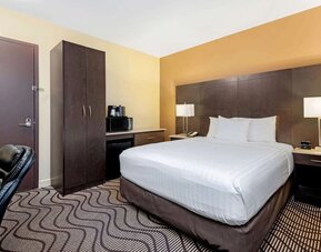 Guest room with a king bed, microwave, and mini fridge at La Quinta Inn & Suites By Wyndham Oshawa.