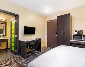 Guest room with a workspace, microwave, and mini fridge at La Quinta Inn & Suites By Wyndham Oshawa.