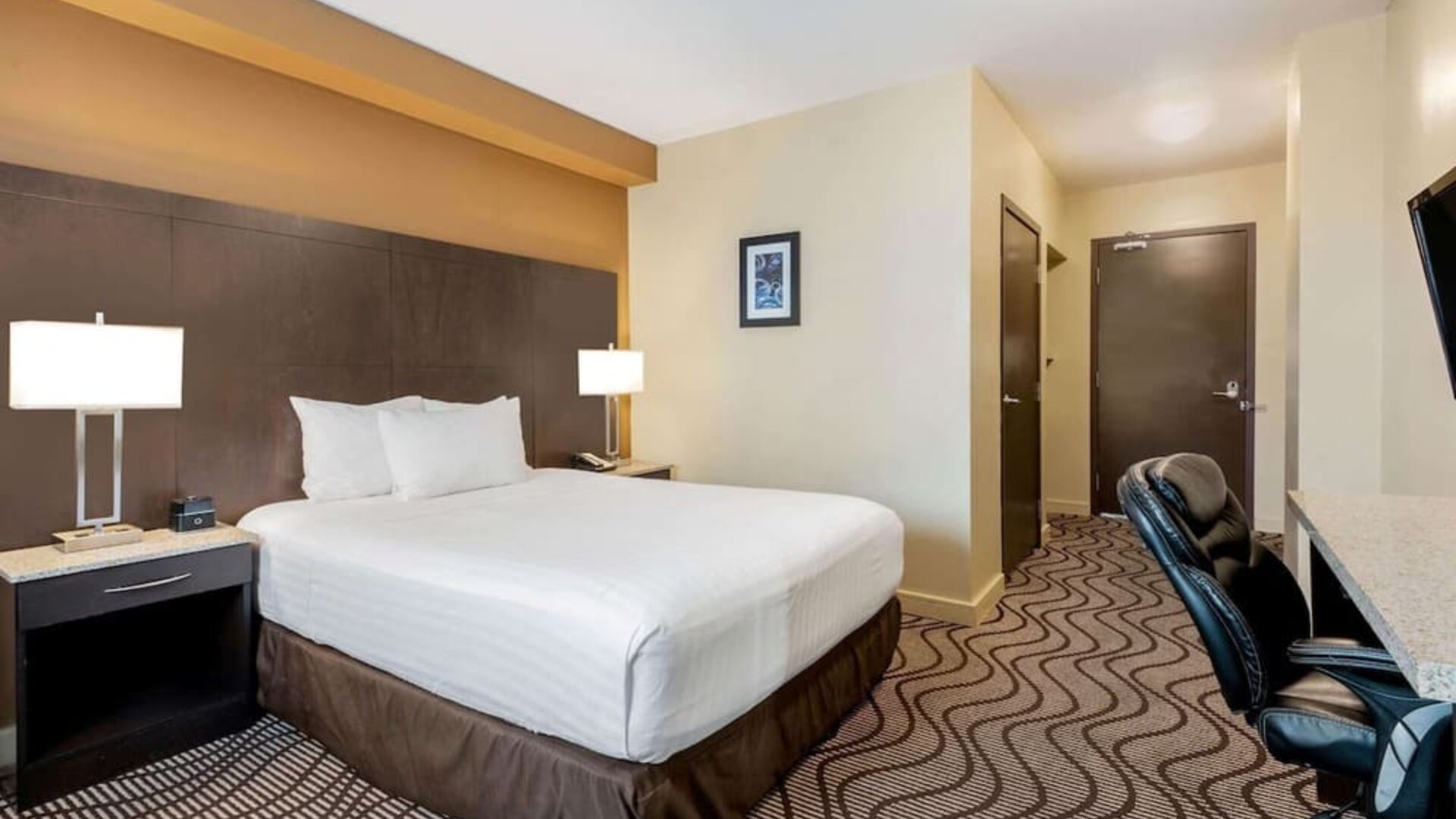 Guest room with a king bed and work desk at La Quinta Inn & Suites By Wyndham Oshawa.