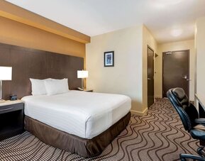 Guest room with a king bed and work desk at La Quinta Inn & Suites By Wyndham Oshawa.