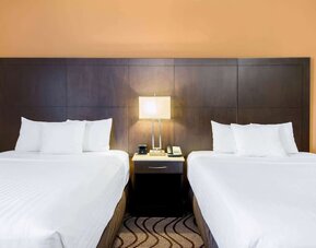 Guest room with two queen beds and work area at La Quinta Inn & Suites By Wyndham Oshawa.