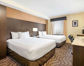 Guest room with two queen beds and bedside table at La Quinta Inn & Suites By Wyndham Oshawa.
