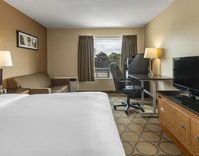 Guest room with a king bed, sofa, and work desk at Comfort Inn Prince Albert.