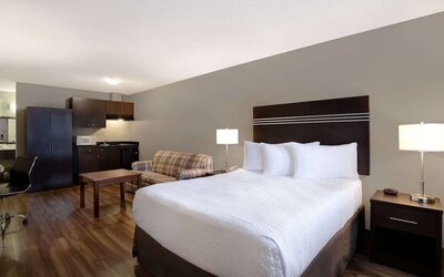 Guest room with a king bed, sofa, and kitchenette at Days Inn Vernon.
