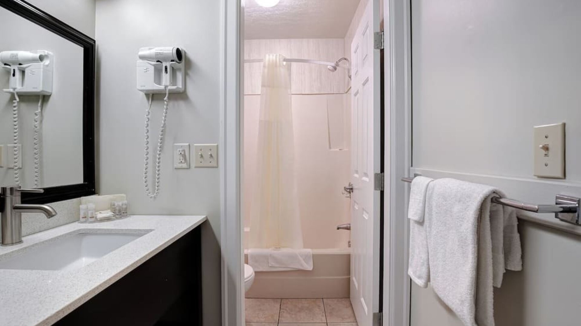 Guest bathroom with a shower and bathtub at Days Inn Vernon.