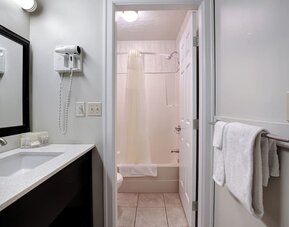 Guest bathroom with a shower and bathtub at Days Inn Vernon.