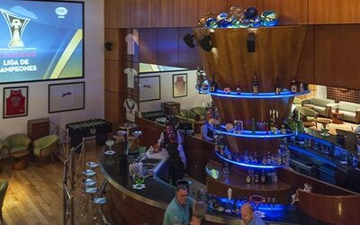 Sports bar with circular illuminated bar, lounge seating and large projection screen at Hotel Casa Blanca.