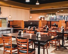 Restaurant dining room with buffet counter, neatly arranged tables and warm ambient lighting at Hotel Lepanto.