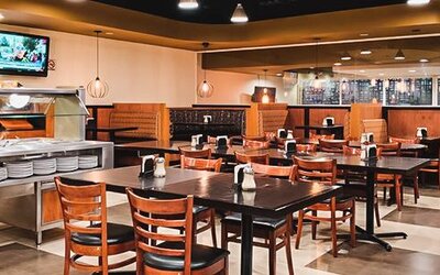 Restaurant dining room with buffet counter, neatly arranged tables and warm ambient lighting at Hotel Lepanto.