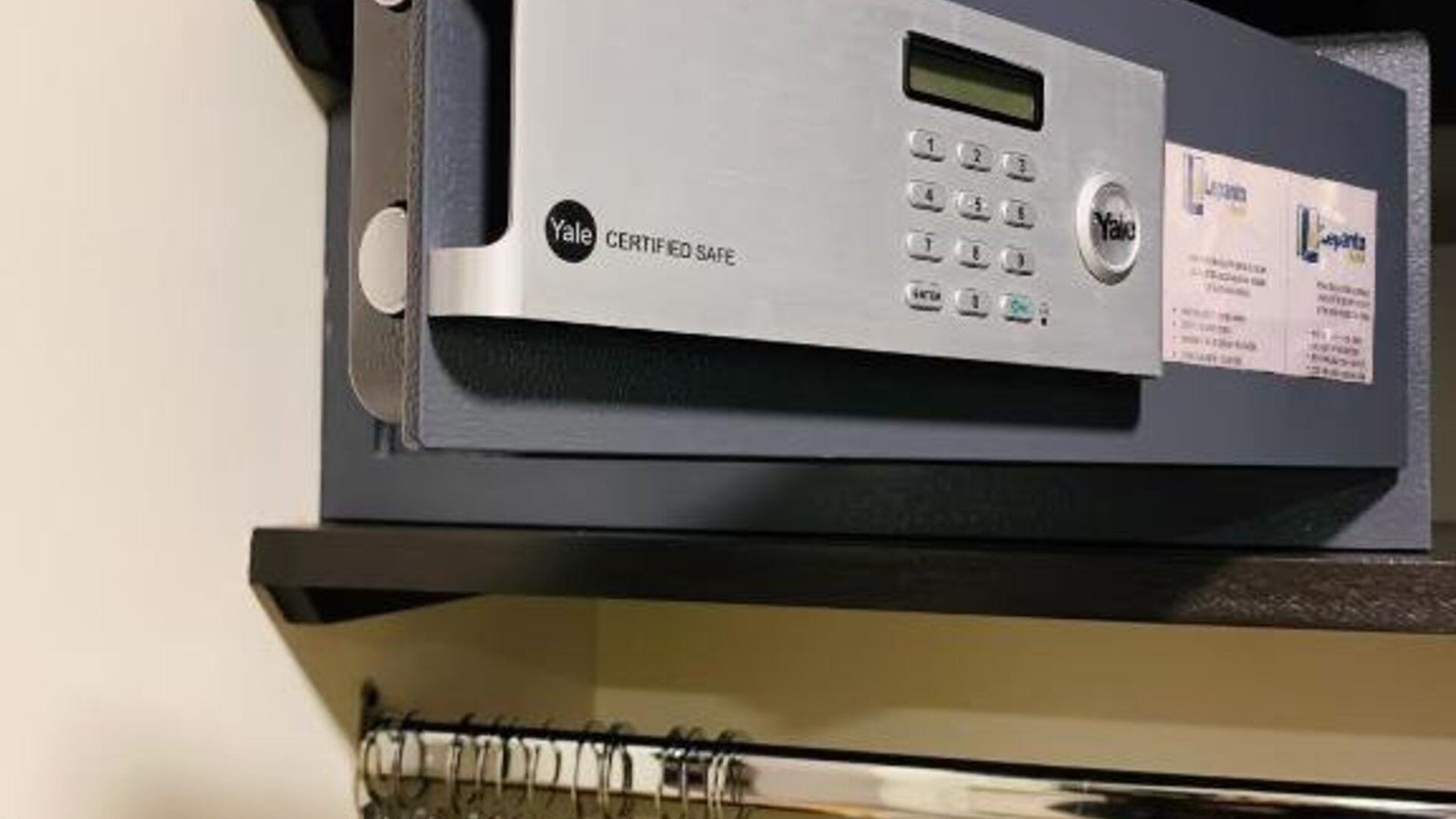In-room wardrobe with electronic safe, hanging rail and wooden clothes hangers at Hotel Lepanto.