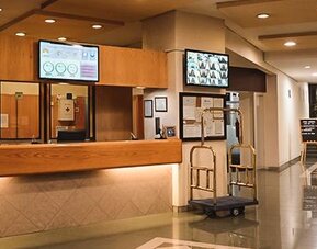 Spacious hotel reception area with front desk, luggage carts and polished tile flooring at Hotel Lepanto.