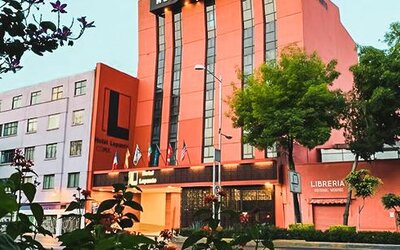 Hotel exterior with entrance, flags and landscaped trees along the surrounding city street at Hotel Lepanto.