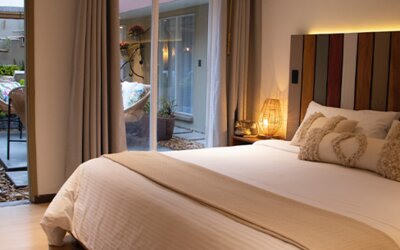 King guest room with decorative pillows and sliding doors opening onto a private courtyard at Marbore Hotel & Spa.