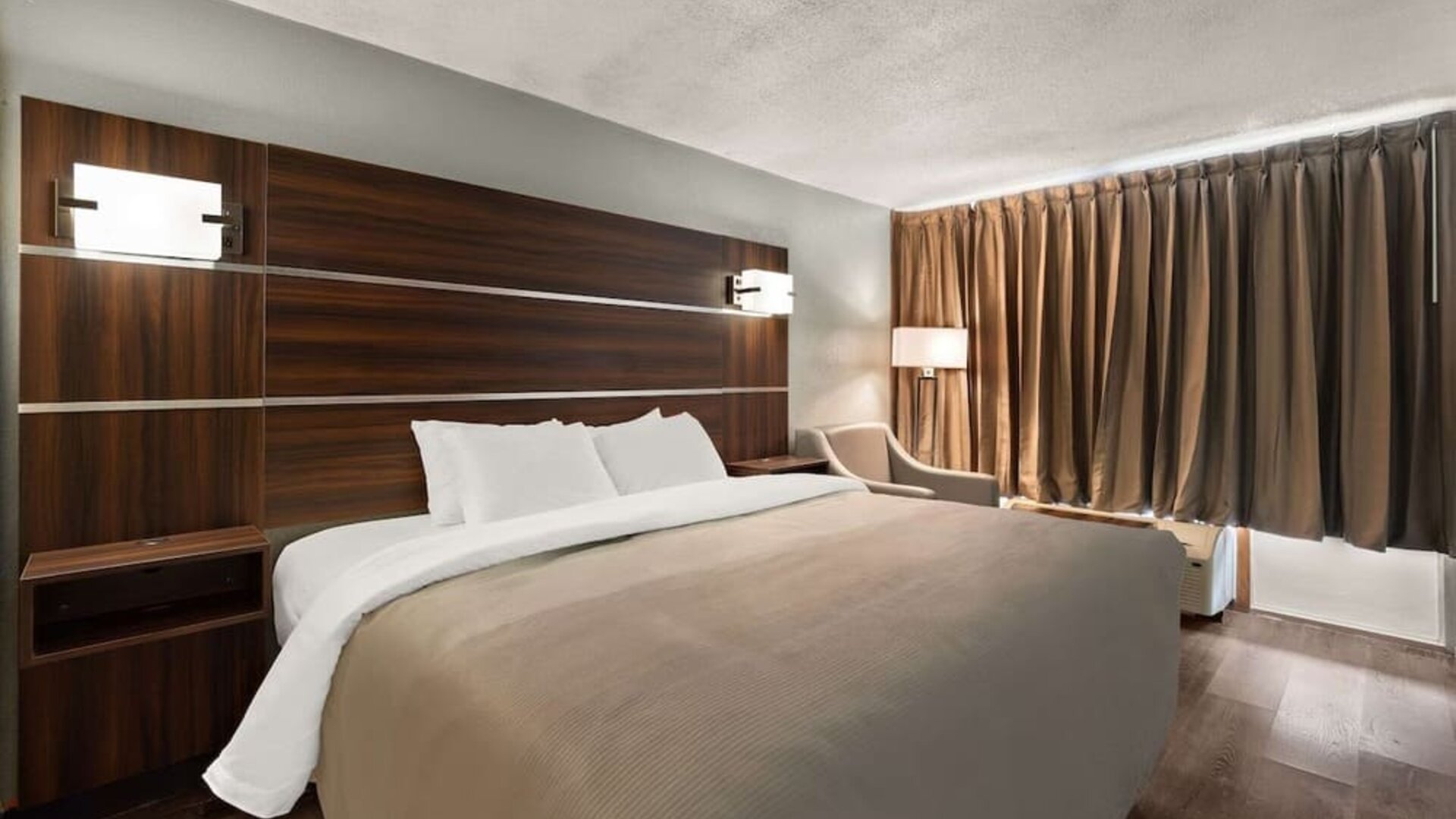King guest room with dark wood headboard, bedside lighting and blackout curtains at Quality Inn Yemassee - Point South I-95.