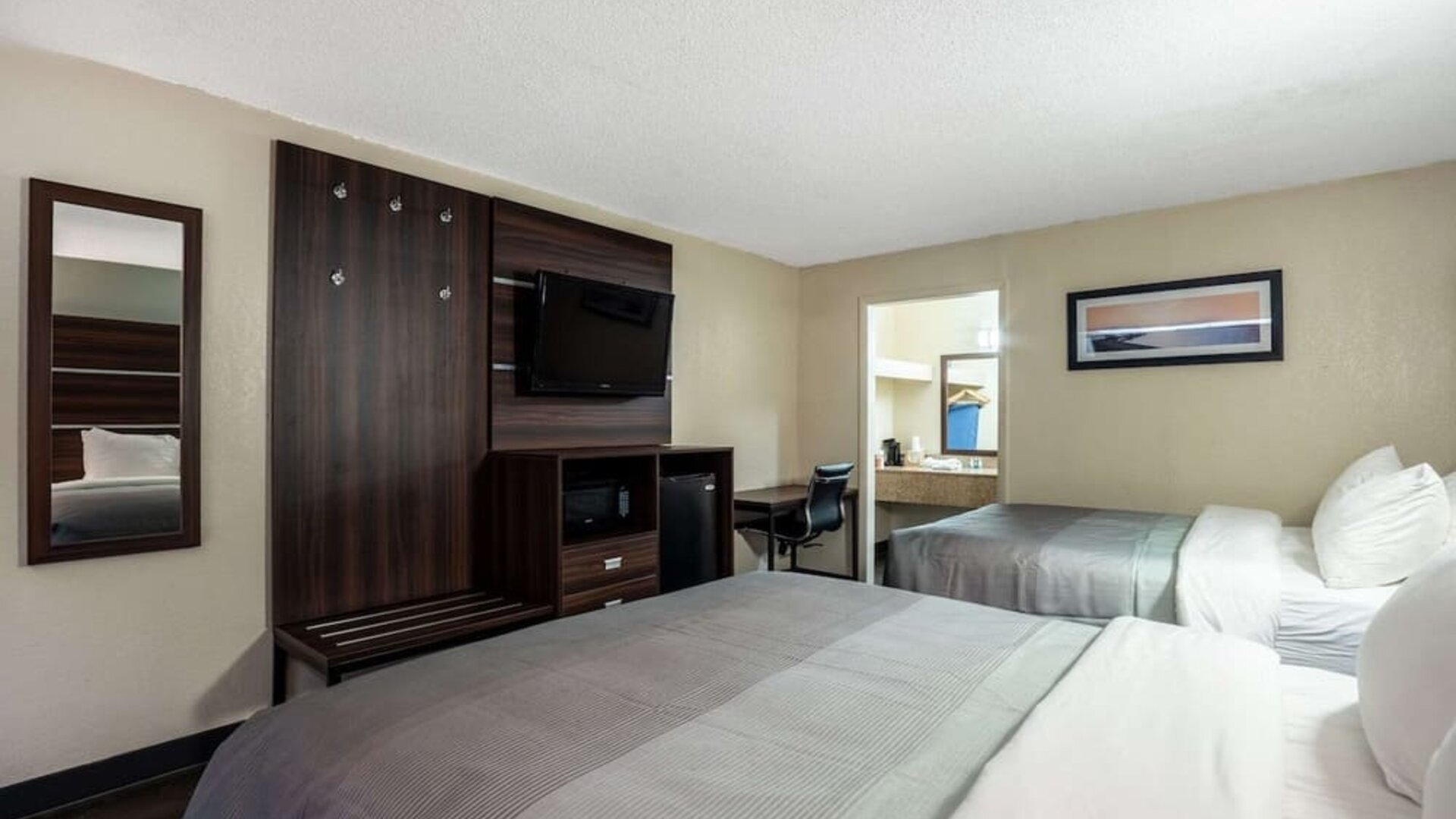 Guest room with two double beds, wall-mounted TV, mini fridge and workspace at Quality Inn Yemassee - Point South I-95.