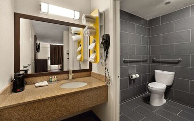 Accessible bathroom with granite vanity, grab bars and roll-in shower area at Quality Inn Yemassee - Point South I-95.