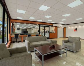 Open lobby seating area with sofas, reception desk and business center workstations at Quality Inn Yemassee - Point South I-95.