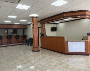 Reception desk with polished tile flooring, guest seating and check-in counter at Econo Lodge Yemassee.