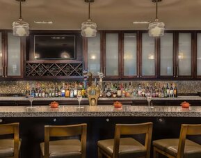 Contemporary hotel bar serving cocktails, beer, wine, and spirits with comfortable seating in a stylish atmosphere.