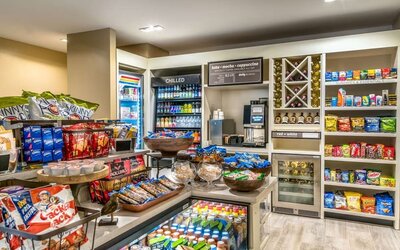 Hotel market stocked with snacks, cold drinks, wine, convenience items, coffee, and grab-and-go refreshments.