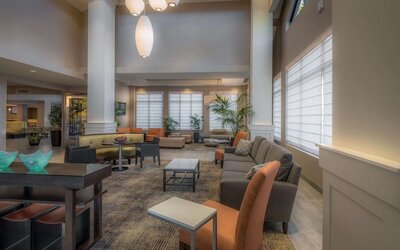Spacious hotel lobby with comfortable seating, high ceilings, natural light, and relaxing areas for work or conversation.