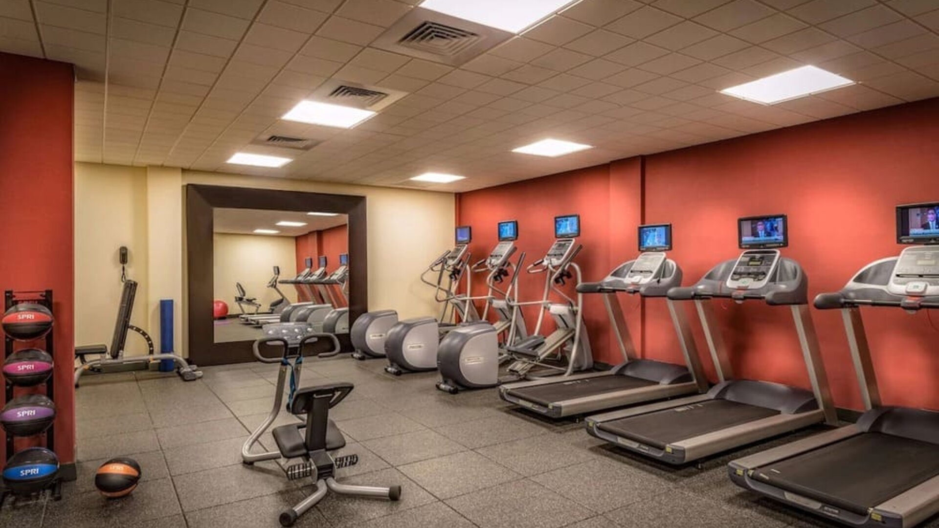 On-site fitness center featuring treadmills, elliptical machines, stationary bike, free weights, and exercise equipment.