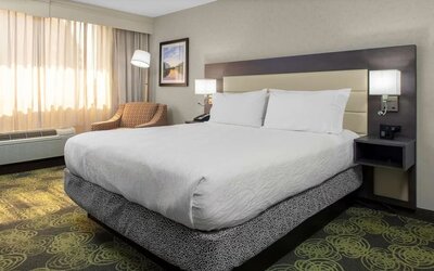 Spacious king suite with separate bedroom, living area, HDTV, work desk, microwave, and comfortable seating.