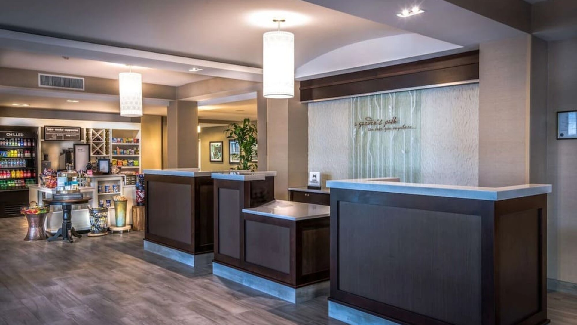 Modern hotel reception area with front desk, lobby market, and welcoming check-in space for arriving guests.