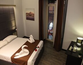 Comfortable double room with balcony access and modern furnishings at Dolce Vita Rooms & Breakfast.