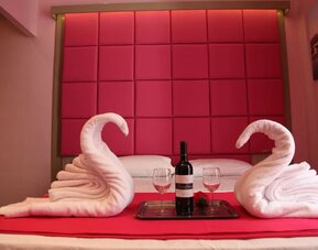 Romantic double room with padded headboard, towel swans and complimentary wine at Dolce Vita Rooms & Breakfast.
