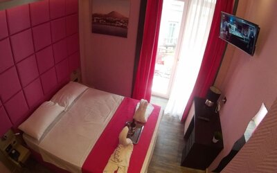 Bright double room with balcony access, flat-screen TV and modern décor at Dolce Vita Rooms & Breakfast.