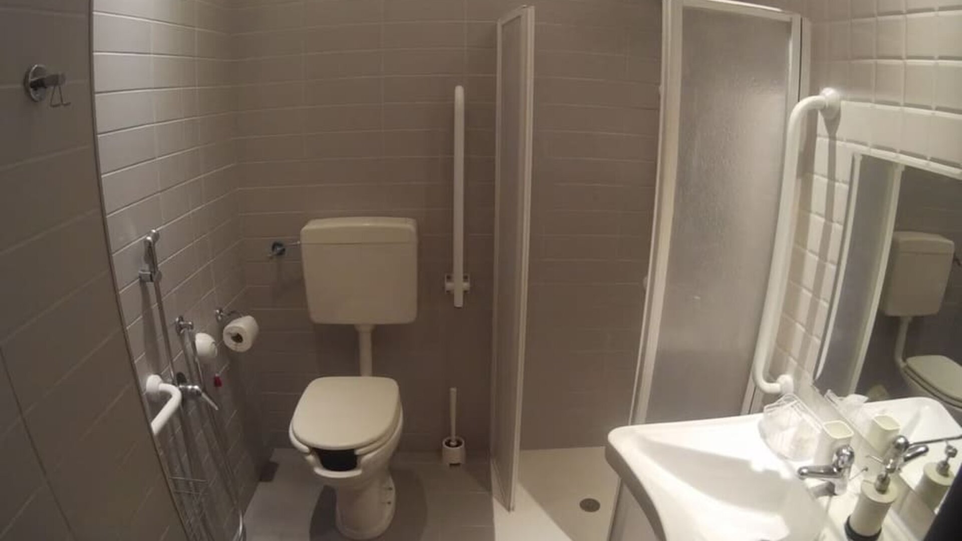 Accessible bathroom with roll-in shower, grab bars and modern fixtures at Dolce Vita Rooms & Breakfast.
