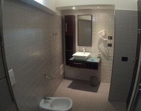 Modern bathroom with glass-enclosed shower, bidet and contemporary vanity at Dolce Vita Rooms & Breakfast.