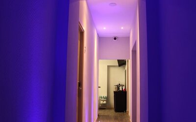 Contemporary hallway with ambient lighting leading to guest rooms at Dolce Vita Rooms & Breakfast.