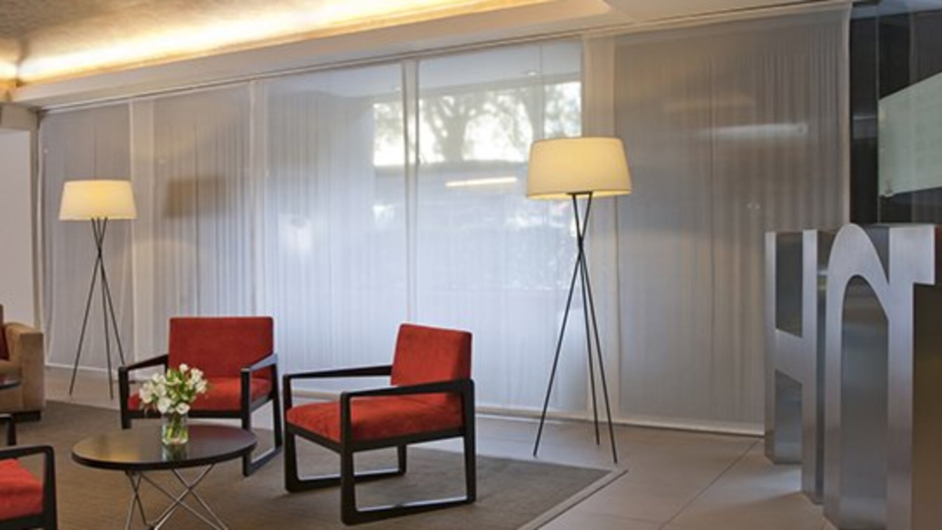 Stylish hotel lobby with comfortable lounge seating, floor-to-ceiling windows and modern décor at NH Buenos Aires 9 De Julio.