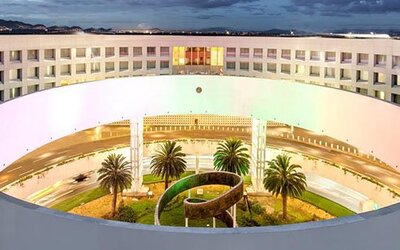Aerial exterior view of NH Collection Mexico City Airport T2 showcasing the hotel's distinctive circular architecture and landscaped central courtyard.
