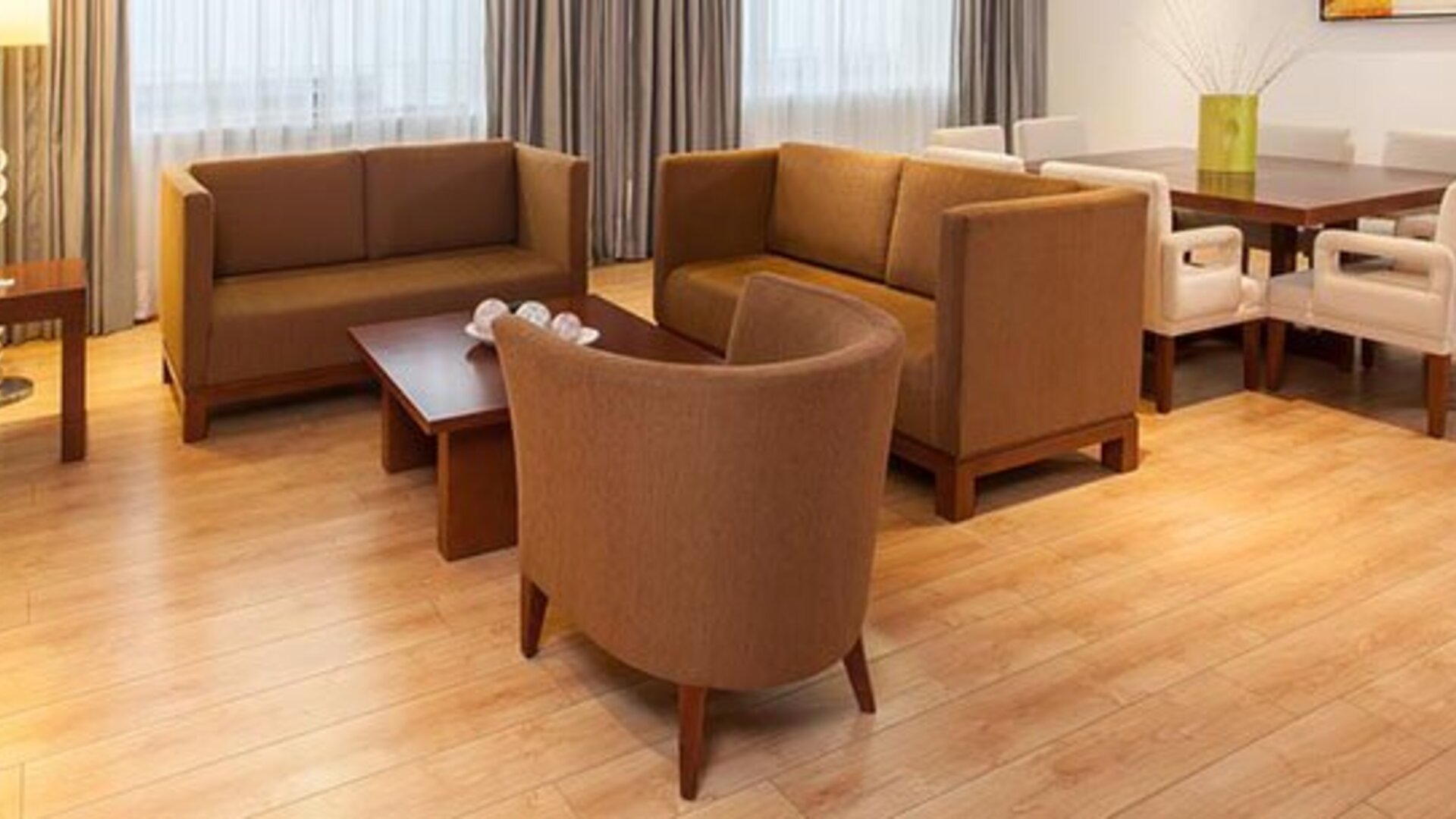 Spacious suite living area with comfortable sofas, dining table and contemporary furnishings at NH Collection Mexico City Airport T2.