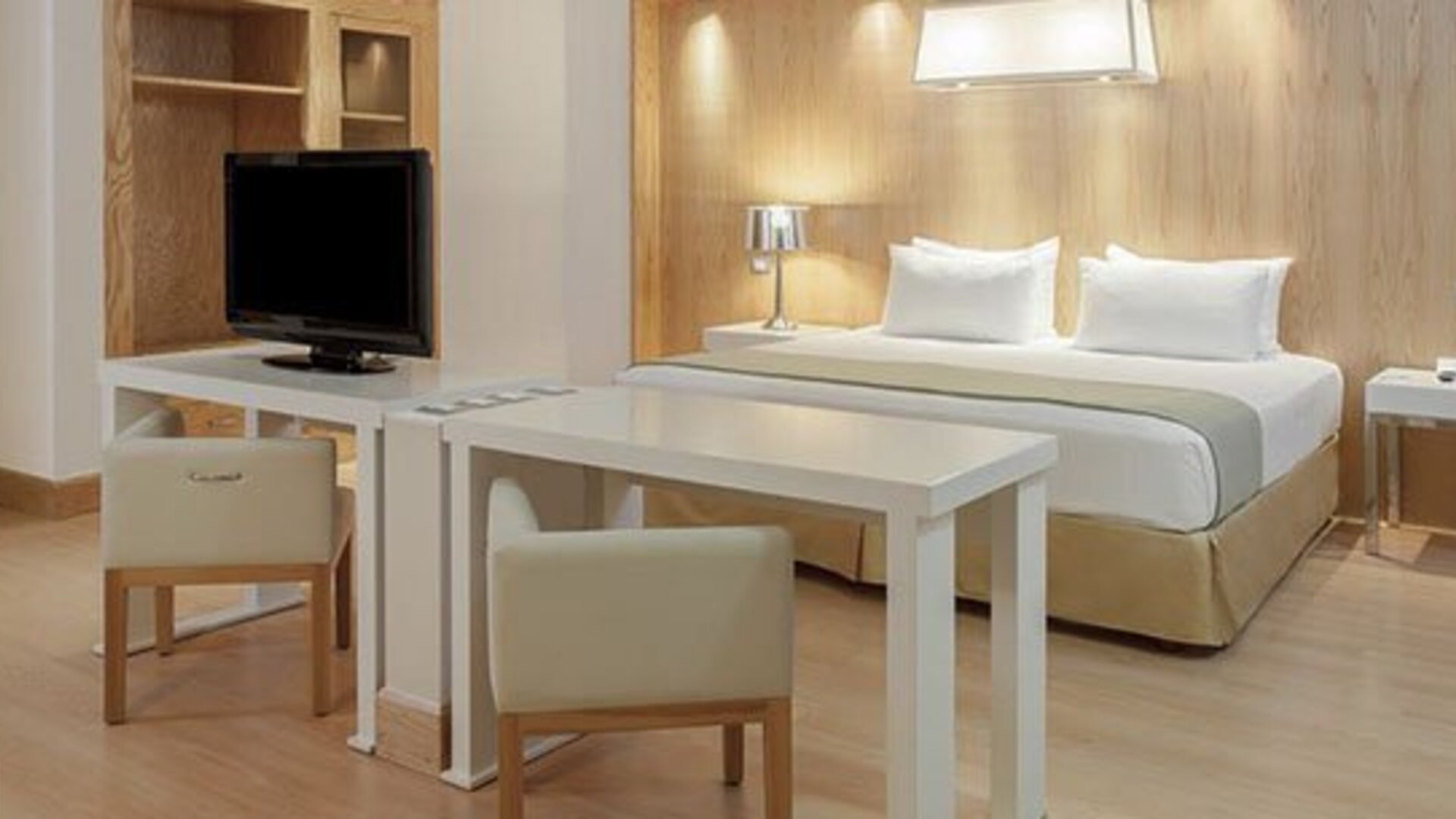 Studio-style suite with king bed, dining table, work area and spacious open-plan layout at NH Collection Mexico City Airport T2.