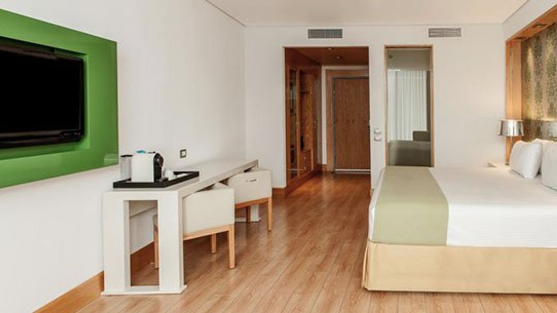 Contemporary guest room with king bed, workspace, flat-screen TV and modern furnishings at NH Collection Mexico City Airport T2.
