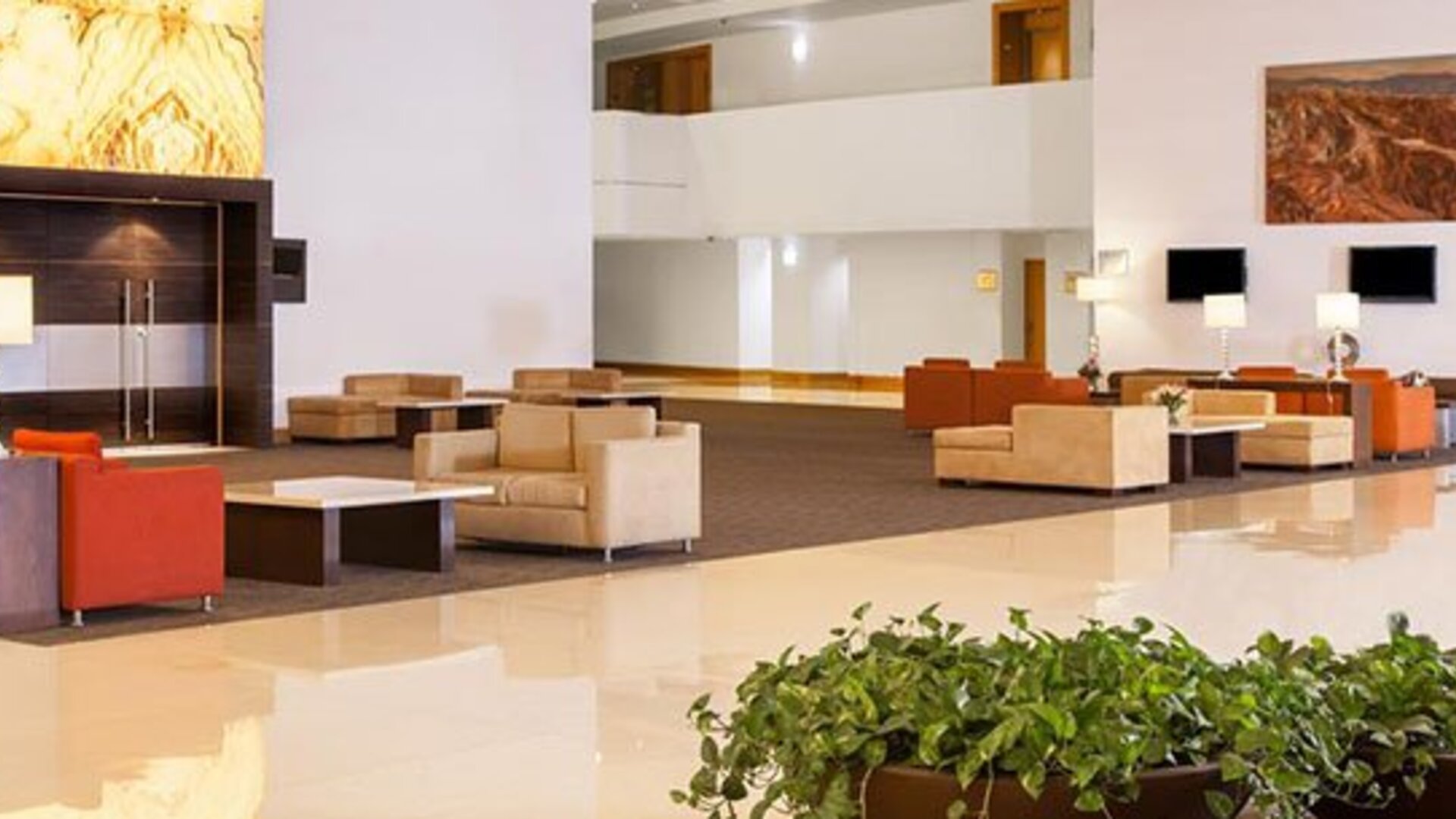 Spacious hotel lobby with contemporary seating, high ceilings and elegant modern décor at NH Collection Mexico City Airport T2.
