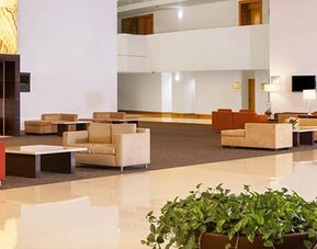 Spacious hotel lobby with contemporary seating, high ceilings and elegant modern décor at NH Collection Mexico City Airport T2.