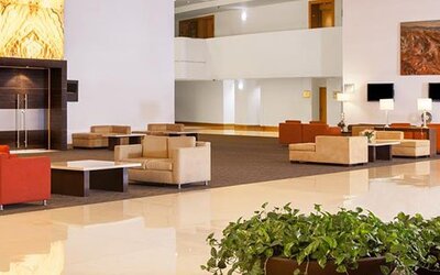 Spacious hotel lobby with contemporary seating, high ceilings and elegant modern décor at NH Collection Mexico City Airport T2.