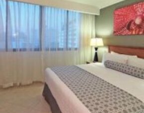 Bright guest room with king bed, large window and contemporary furnishings at Crowne Plaza Panama.