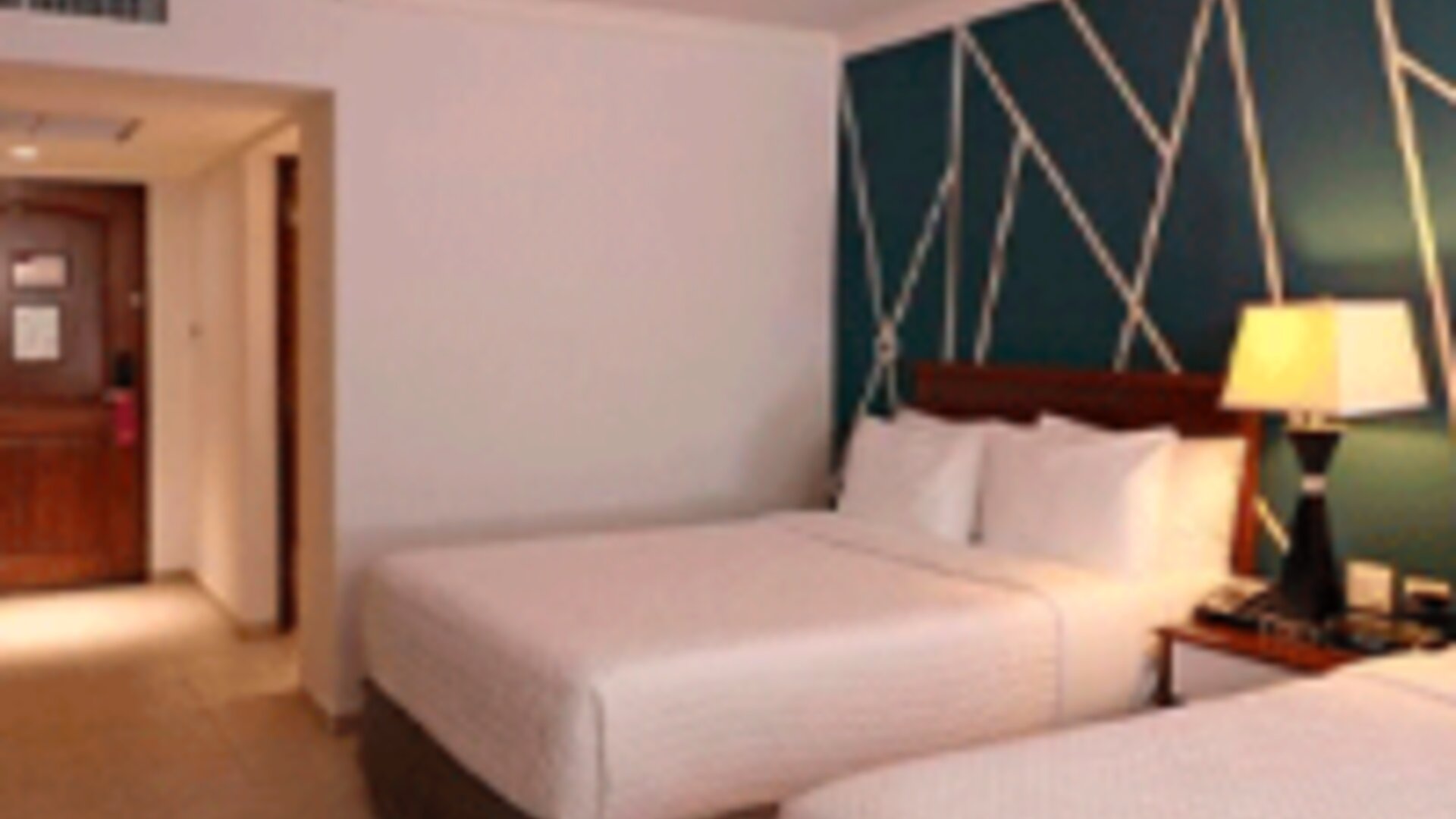 Modern guest room with two double beds, accent feature wall and contemporary décor at Crowne Plaza Panama.