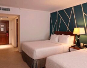 Modern guest room with two double beds, accent feature wall and contemporary décor at Crowne Plaza Panama.