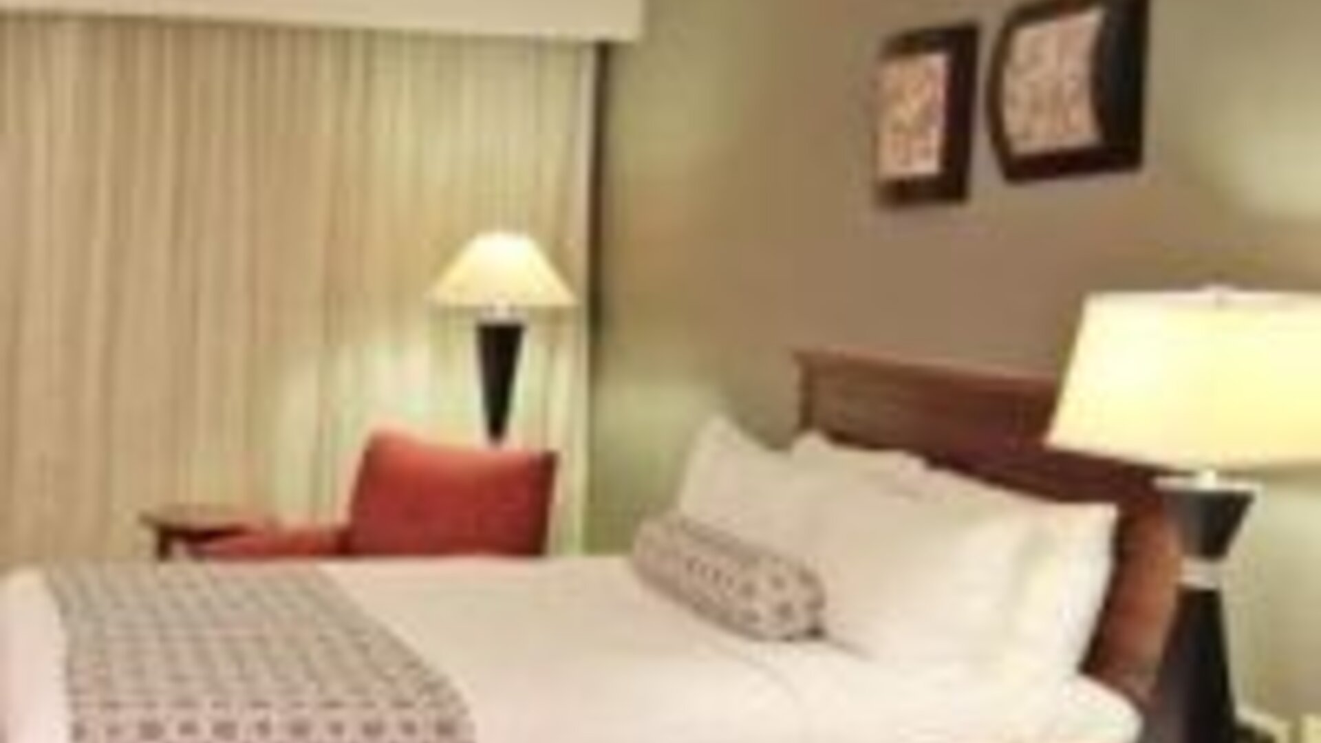 Bright guest room with two double beds, bedside lighting and comfortable seating at Crowne Plaza Panama.