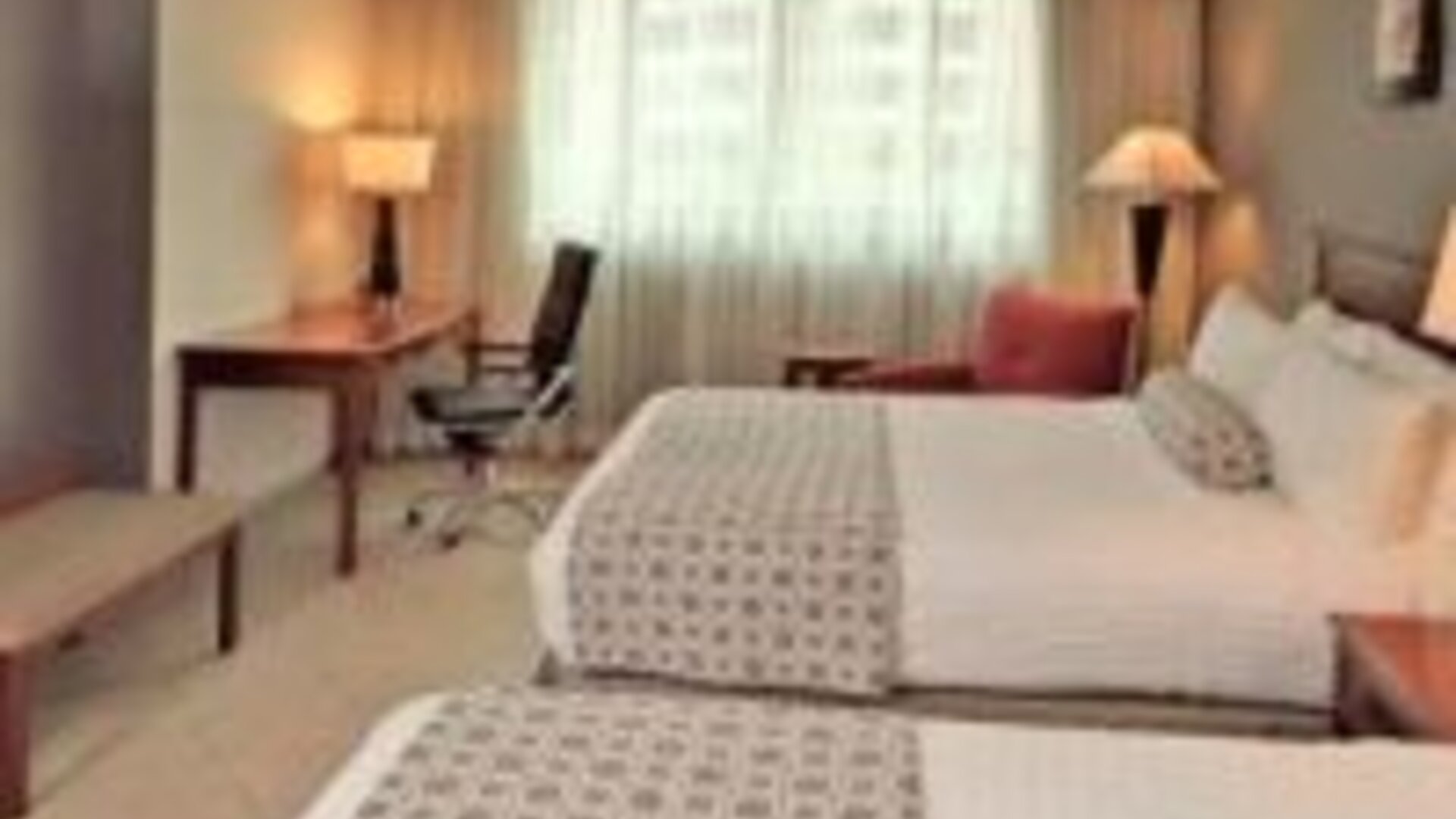 Contemporary guest room featuring two double beds, work area and modern furnishings at Crowne Plaza Panama.
