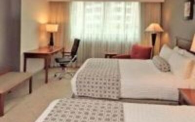 Contemporary guest room featuring two double beds, work area and modern furnishings at Crowne Plaza Panama.